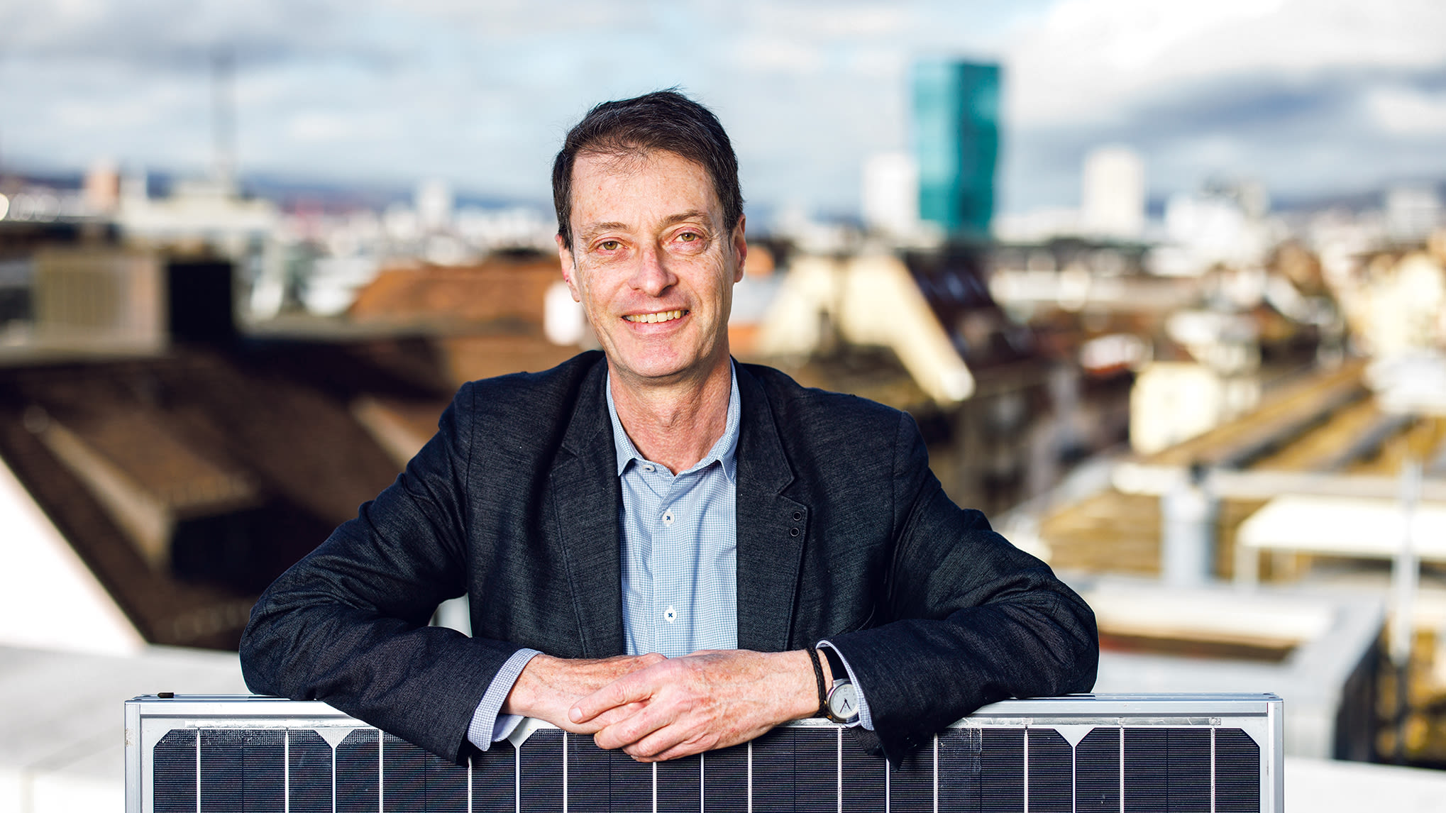 David Stickelberger si trova su un tetto con un pannello solare