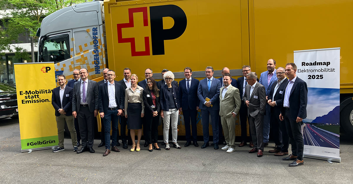 Entscheidungsträger von Post und Bund stehen vor einem elektrischen Lastwagen und stellen das Projekt Roadmap Elektromobilität vor