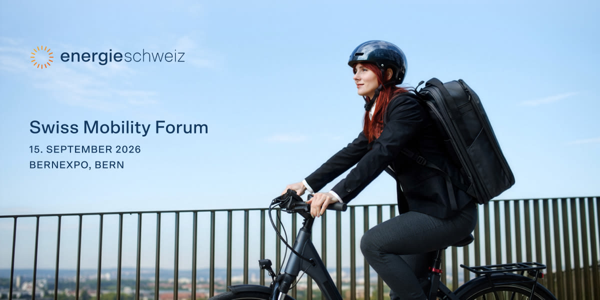 Frau mit Helm und Rucksack fährt E-Bike vor blauem Himmel.