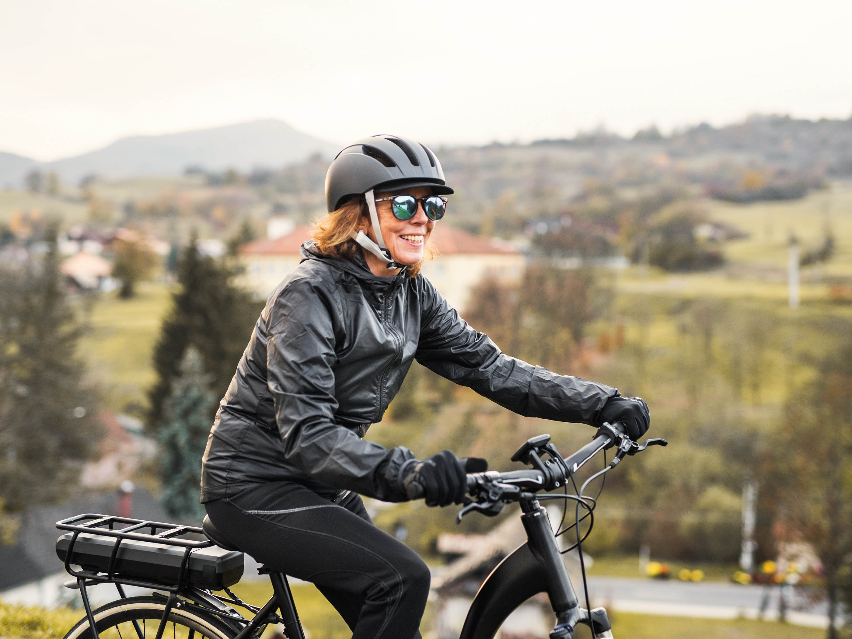 Una donna cavalca la sua bicicletta elettrica attraverso la campagna