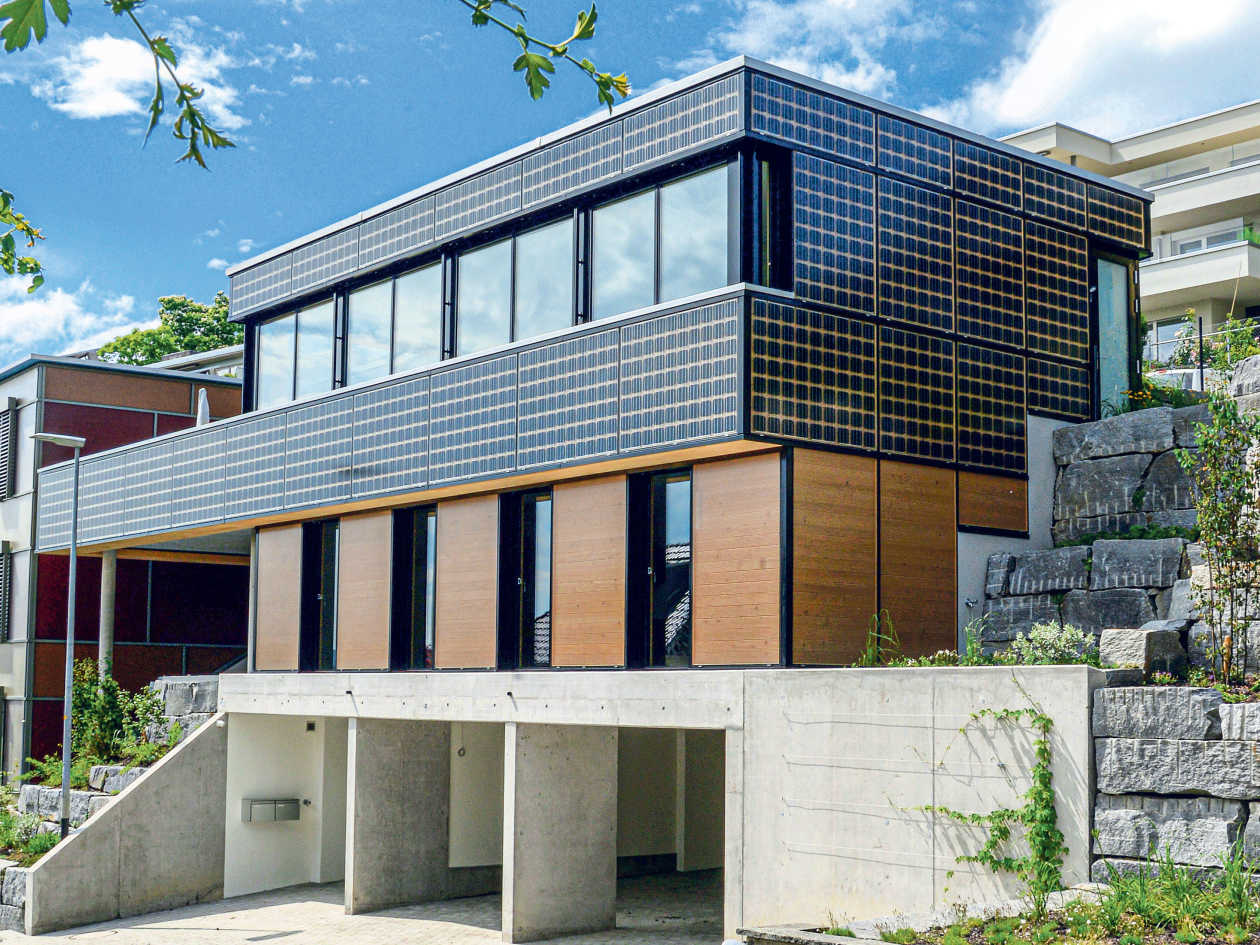 Die PV-Fassadenanlage des Plusenergie-Doppeleinfamilienhauses in Wil (SG) nutzt auch das von der Fassade reflektierte Sonnenlicht. Die erwärmte Luft zwischen PV-Anlage und Fassade wird für den Betrieb einer Wärmepumpe verwendet.
