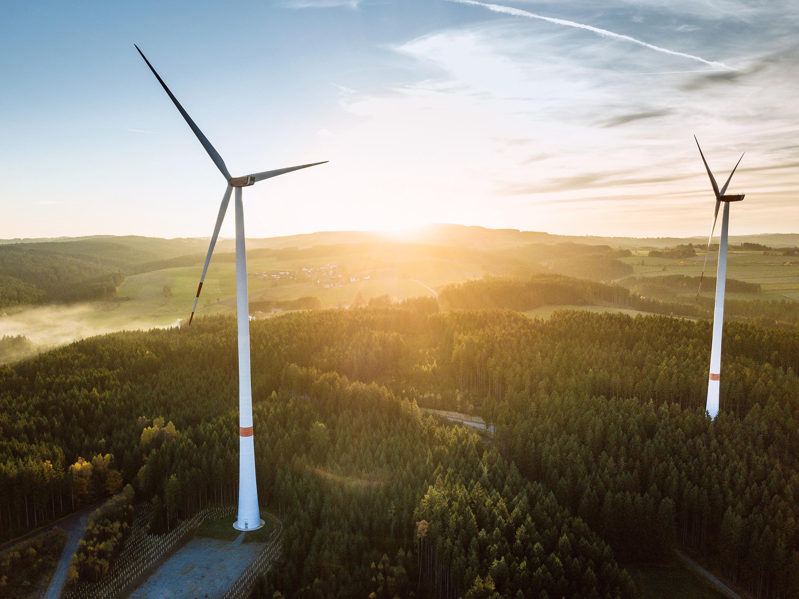 Deux éoliennes au lever du soleil dans la nature.