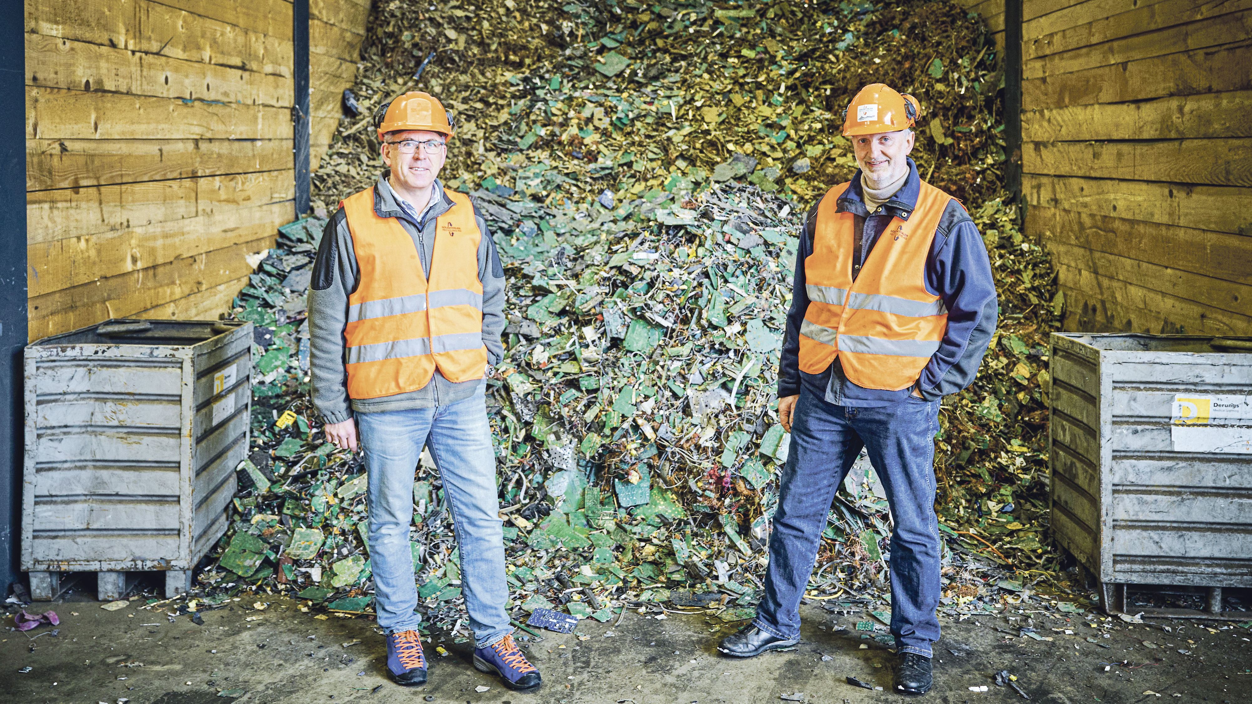 Deux hommes à Solenthaler Recycling AG à Gossau (SG) devant des appareils électriques démontés pour le recyclage