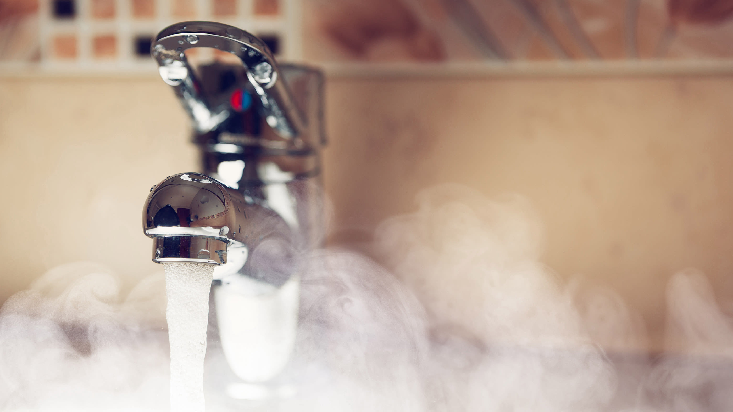 L'eau chaude coule d'un robinet.
