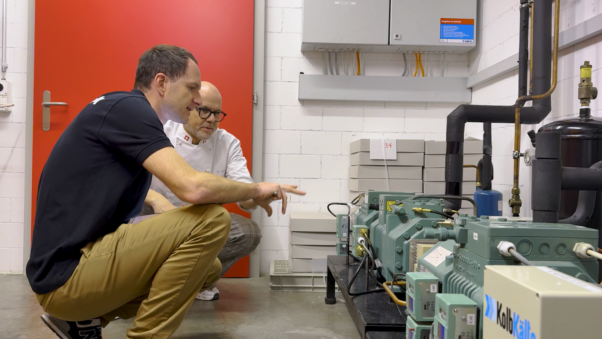 Consulenza energetica presso Cornetto AG: 2 uomini esaminano impianti di refrigerazione e tubazioni in un locale tecnico.