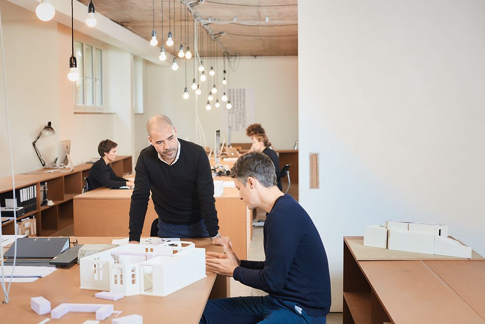 Due colleghi in uno studio di architettura che si consultano.