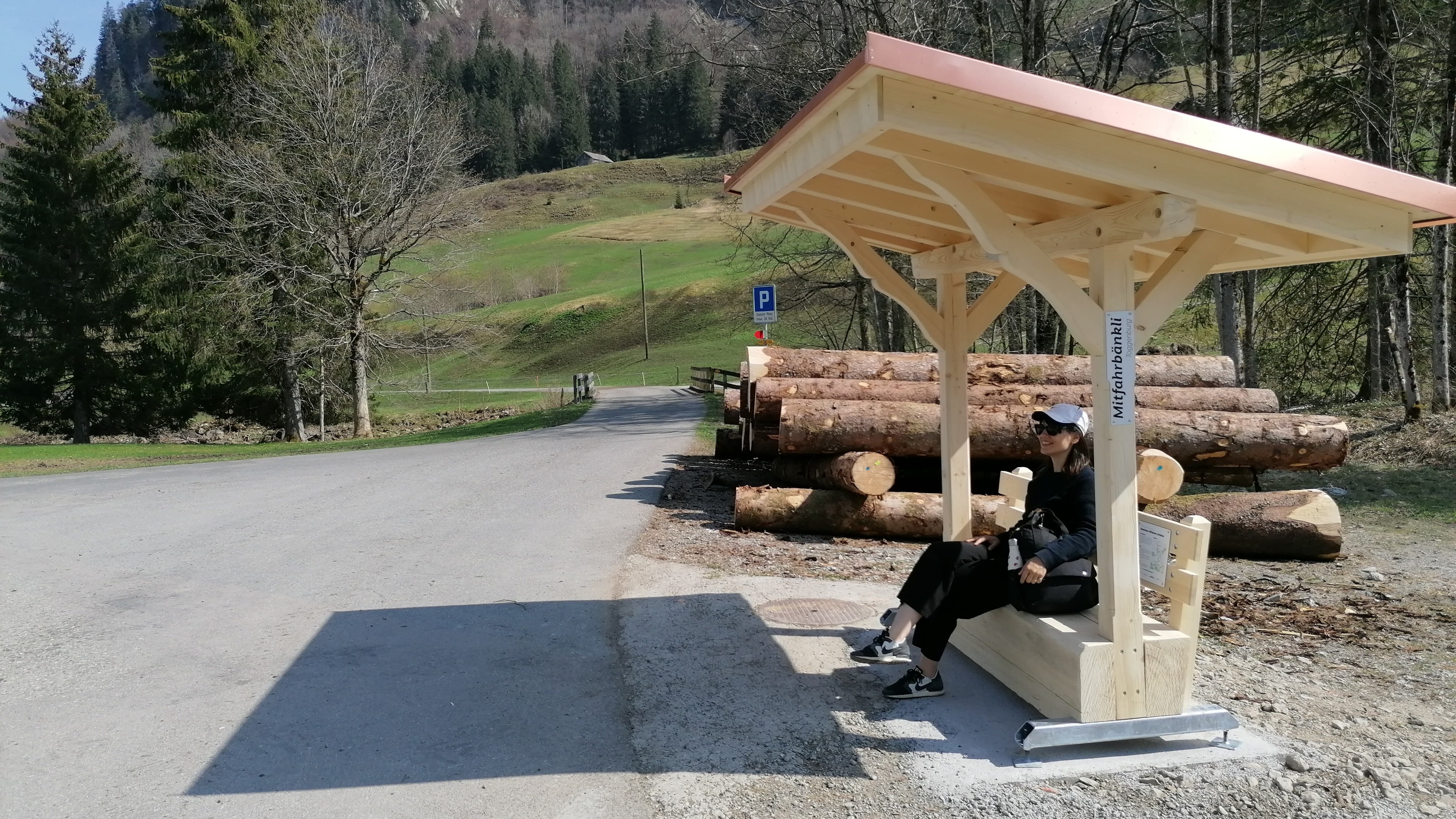 Une femme est assise sur le banc de covoiturage.