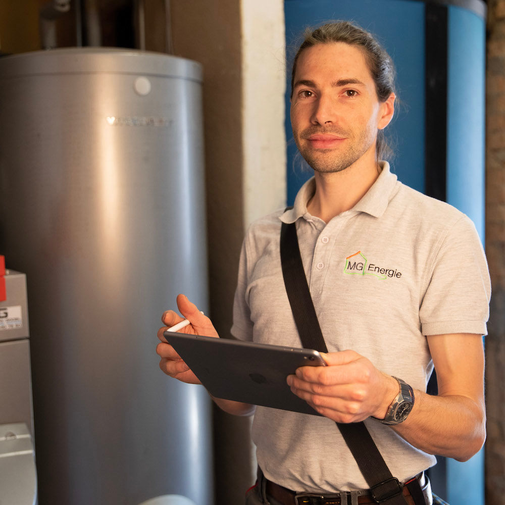 Le consultant Guillaume Marie avec une tablette devant un radiateur