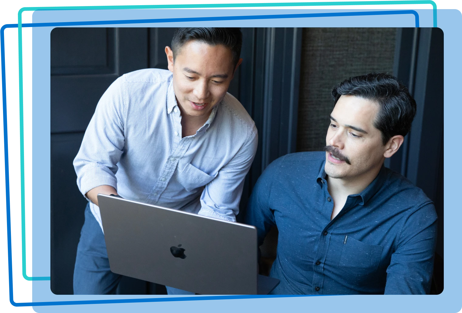 Two men working together on a laptop
