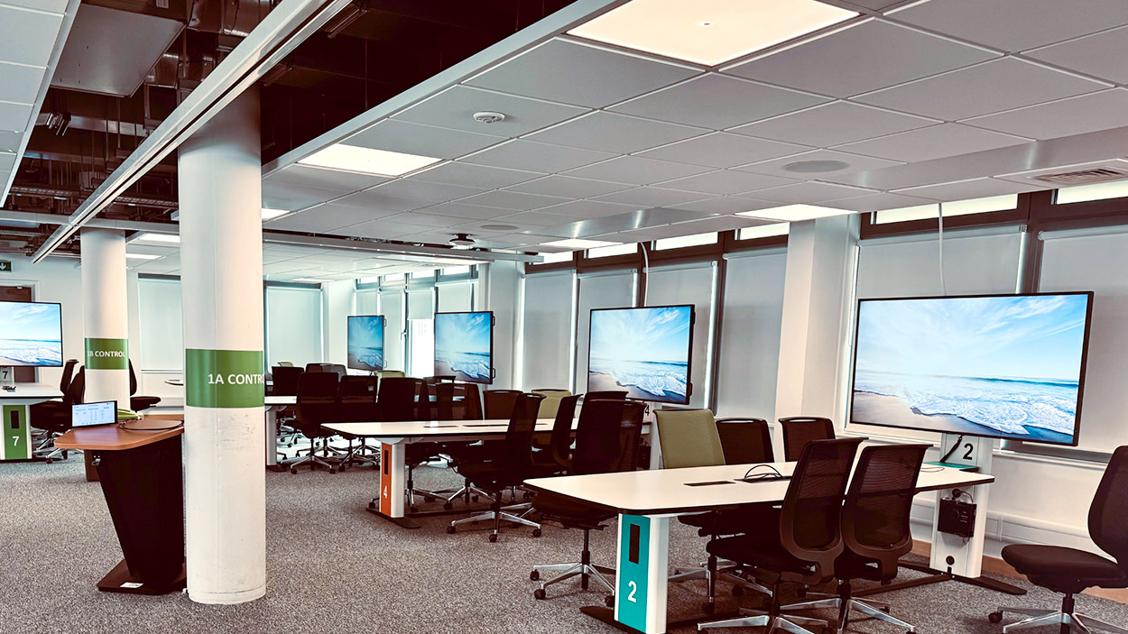 Collaboration space at the University of Portsmouth featuring multiple large interactive displays, shared workstations and flexible seating with 4435 Genelec installed loudspeakers.