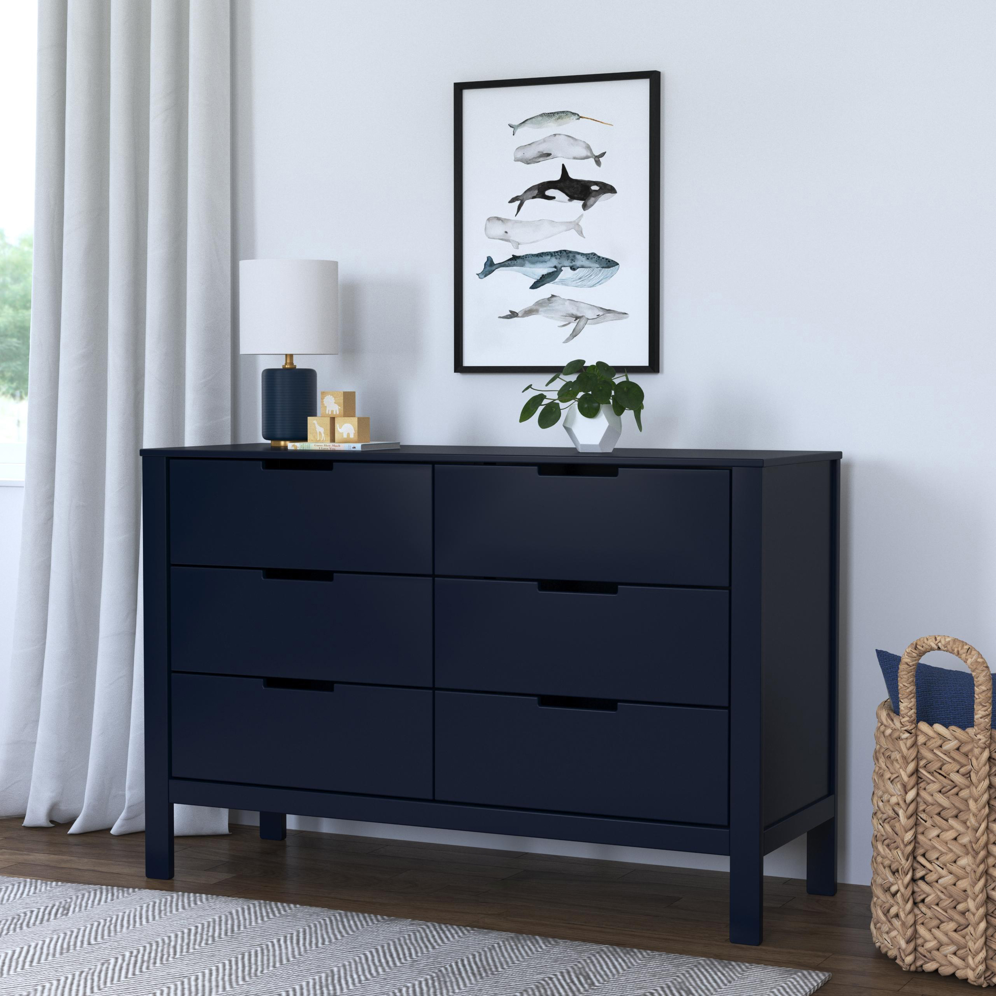 Dresser in a room with lamp and plant
