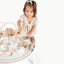Toddler playing with wooden toys on the table.