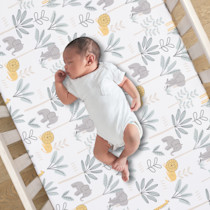 Baby lying in crib on animal-print bedding