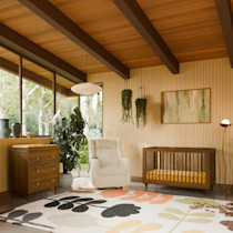 Nursery room with large windows and crib in walnut finish