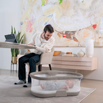 Man using a Halo bassinet with a baby.