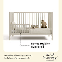 White crib with toddler guardrail and stuffed animal.