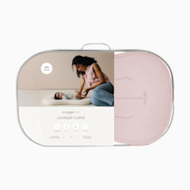 Woman using Snuggle Me Lounger Curve in a bedroom.