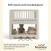 Bassinet with a teddy bear and folded blankets on the bottom shelf.
