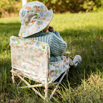 Rear view of booster chair on grass with child