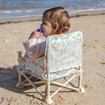 Child in booster chair at the beach