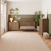Bedroom scene with wooden furniture including a crib and chest.