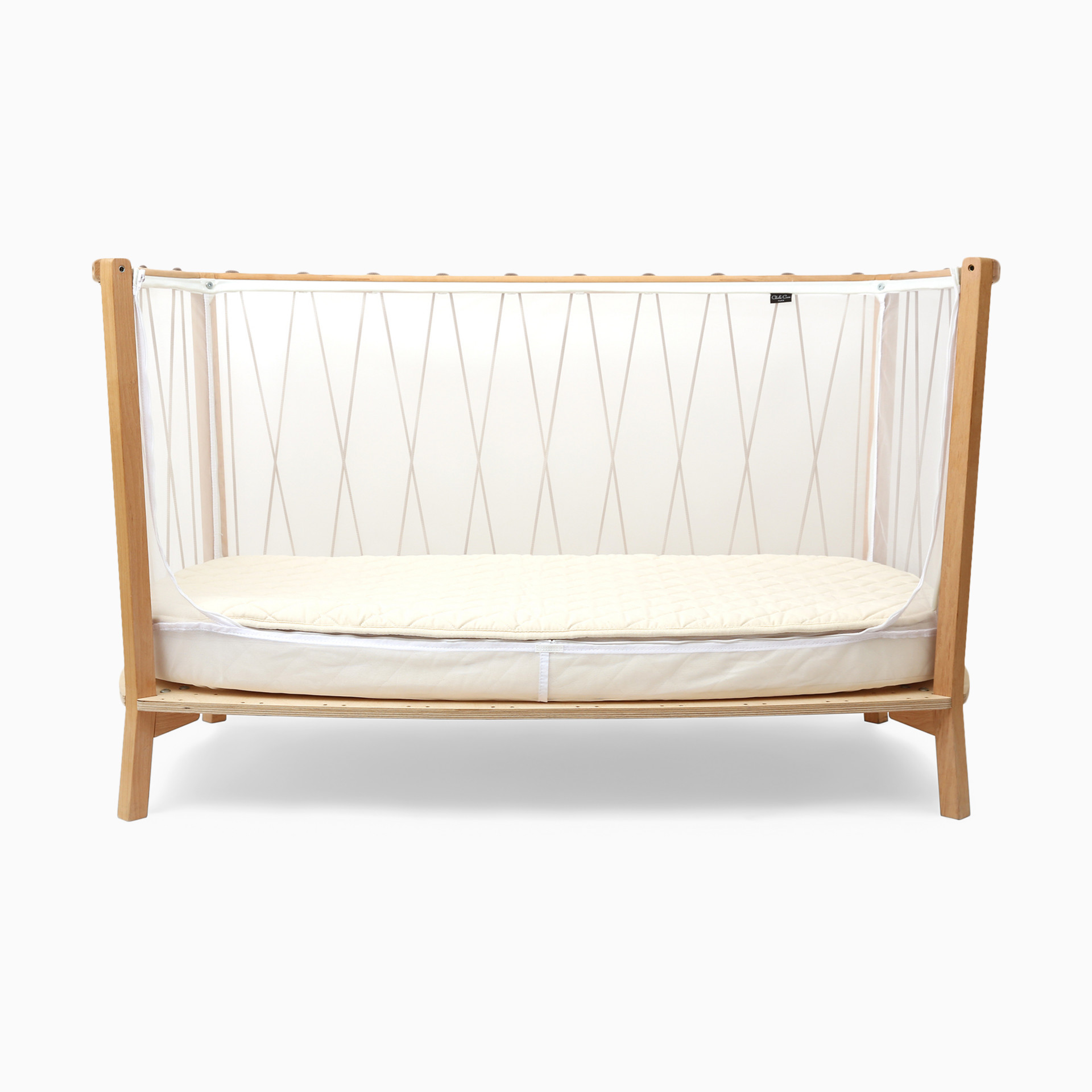 Rectangular wooden baby crib with white sheer canopy.