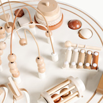 Wooden activity table with various wooden toys.