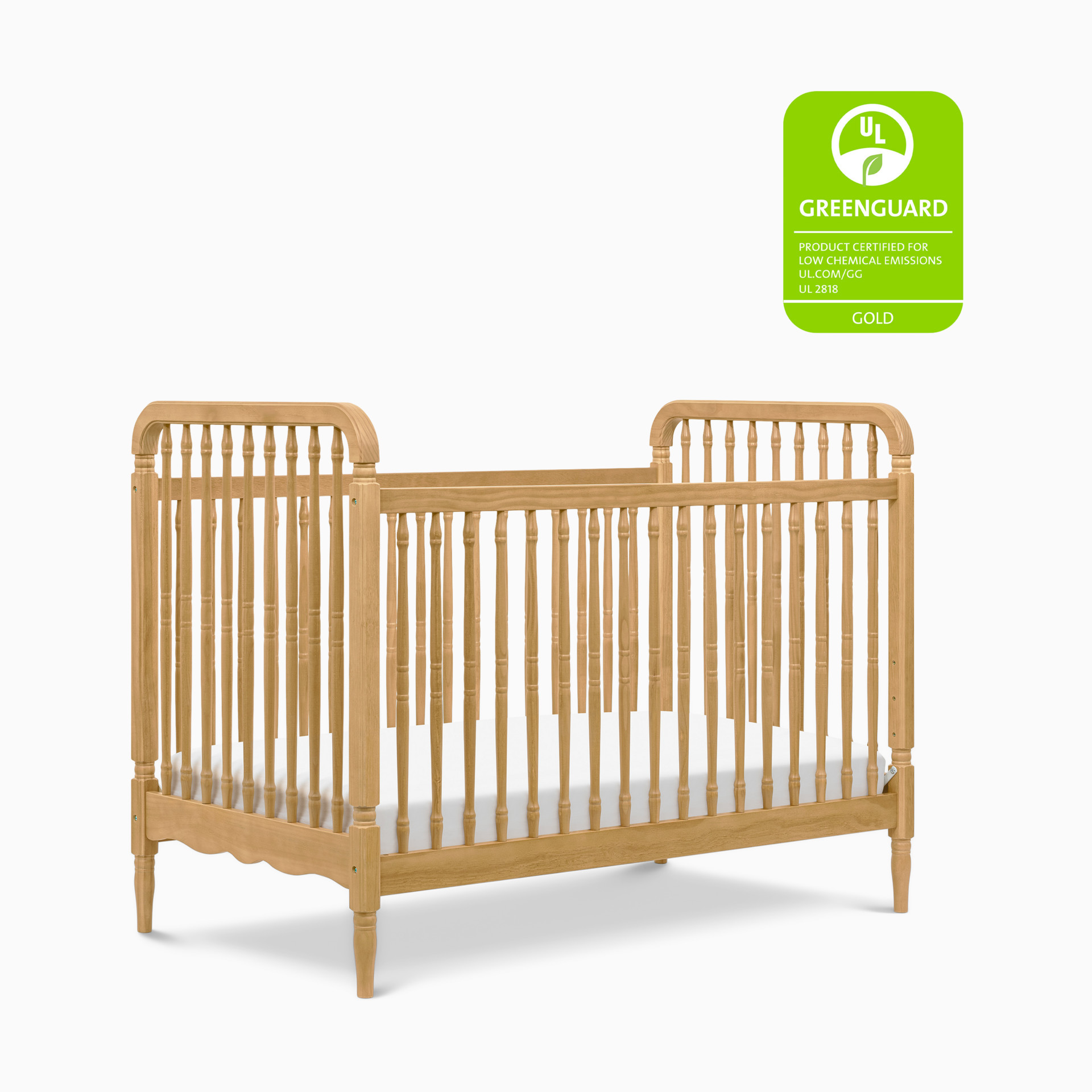 Wooden spindle crib with natural wood finish and Greenguard badge.