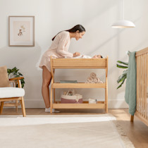 A caregiver and a baby on the changing table in a nursery