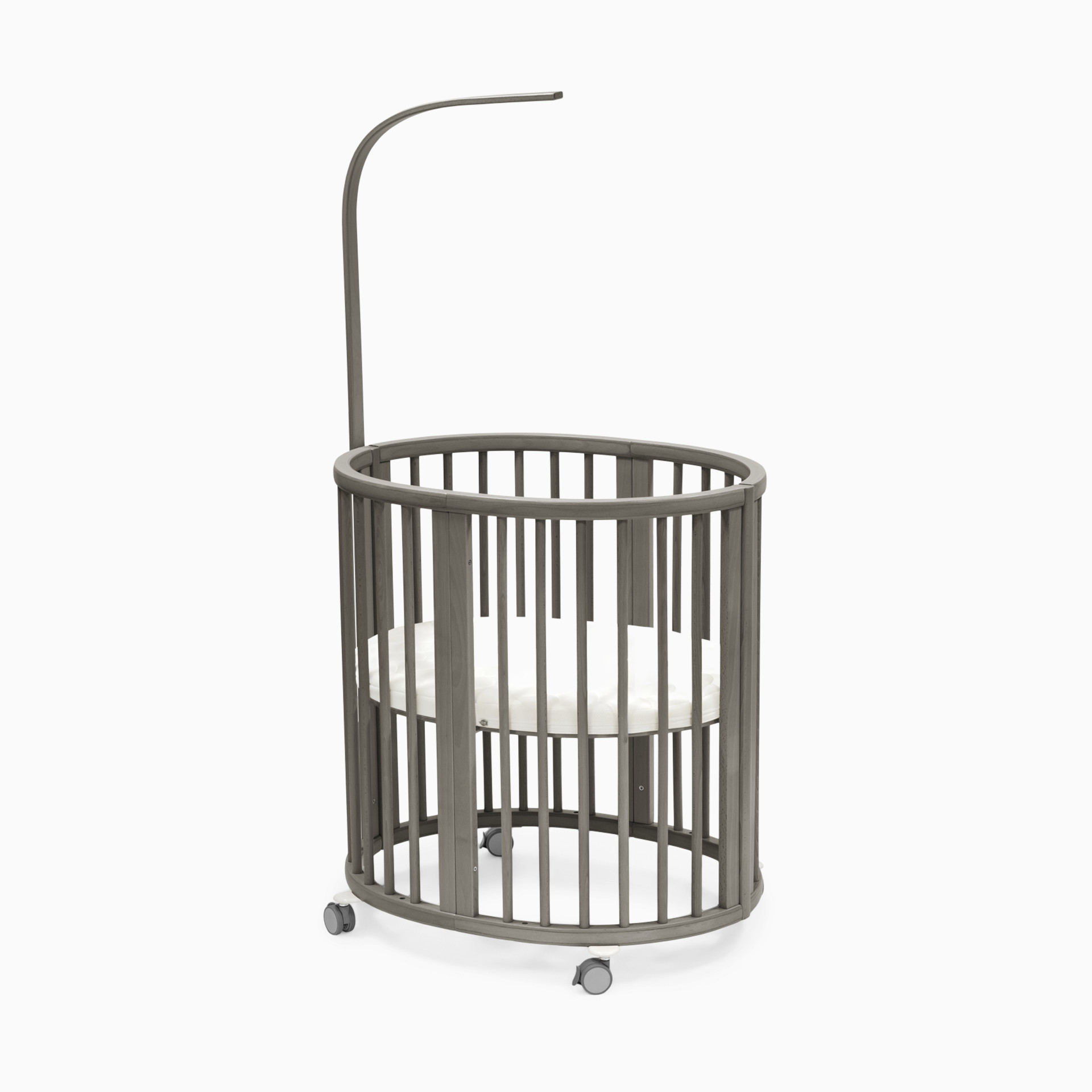 Grey rattan baby crib with curved canopy and wheels on a white background.