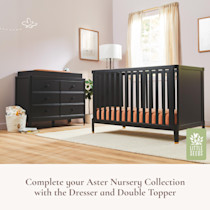Black crib in a nursery room with dresser, Little Seeds logo