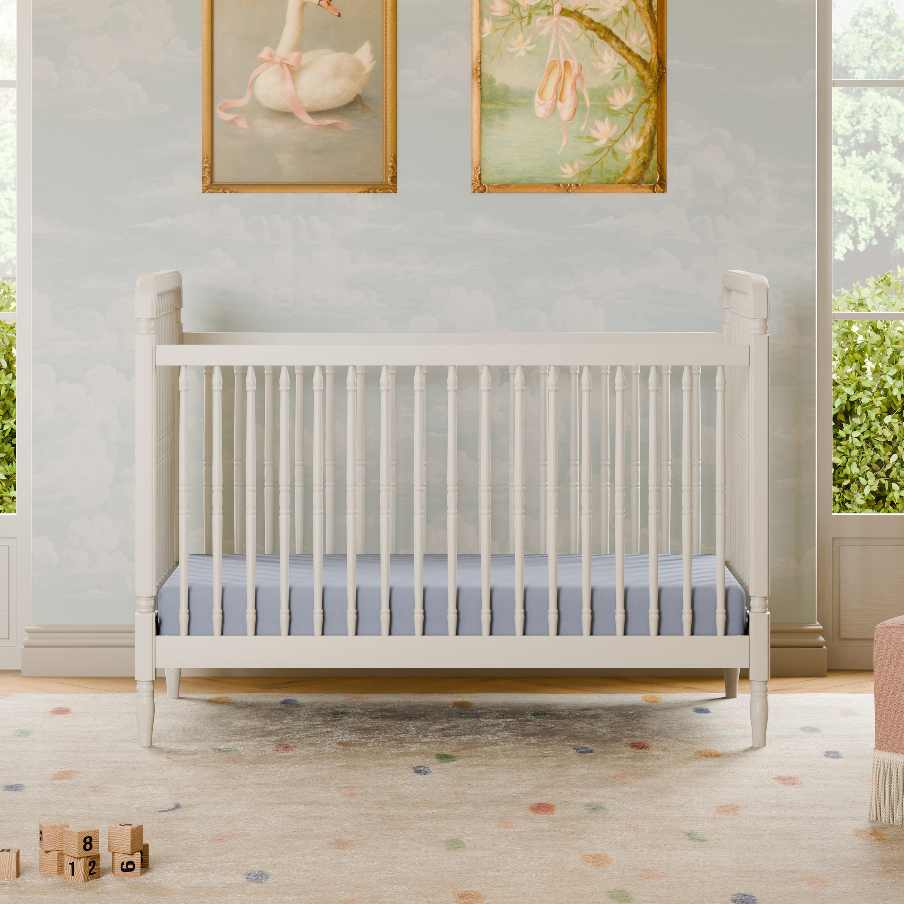 White wooden spindle crib with light blue bedding.