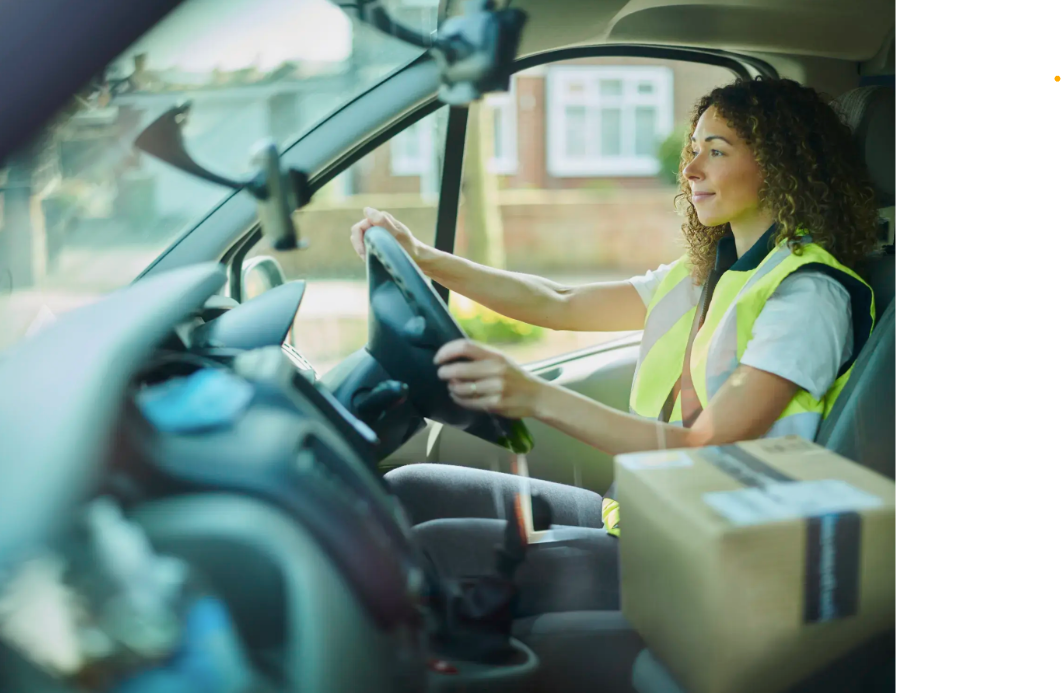 Woman sits in van with amazon parcel on the passenger seat