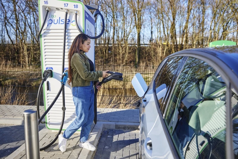 An image of a woman charging her car at bp pulse station