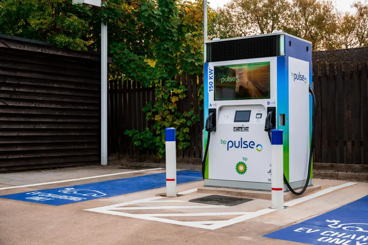 A photo of a bp pulse 150 kWh charger in a forecourt. It is ready to be used