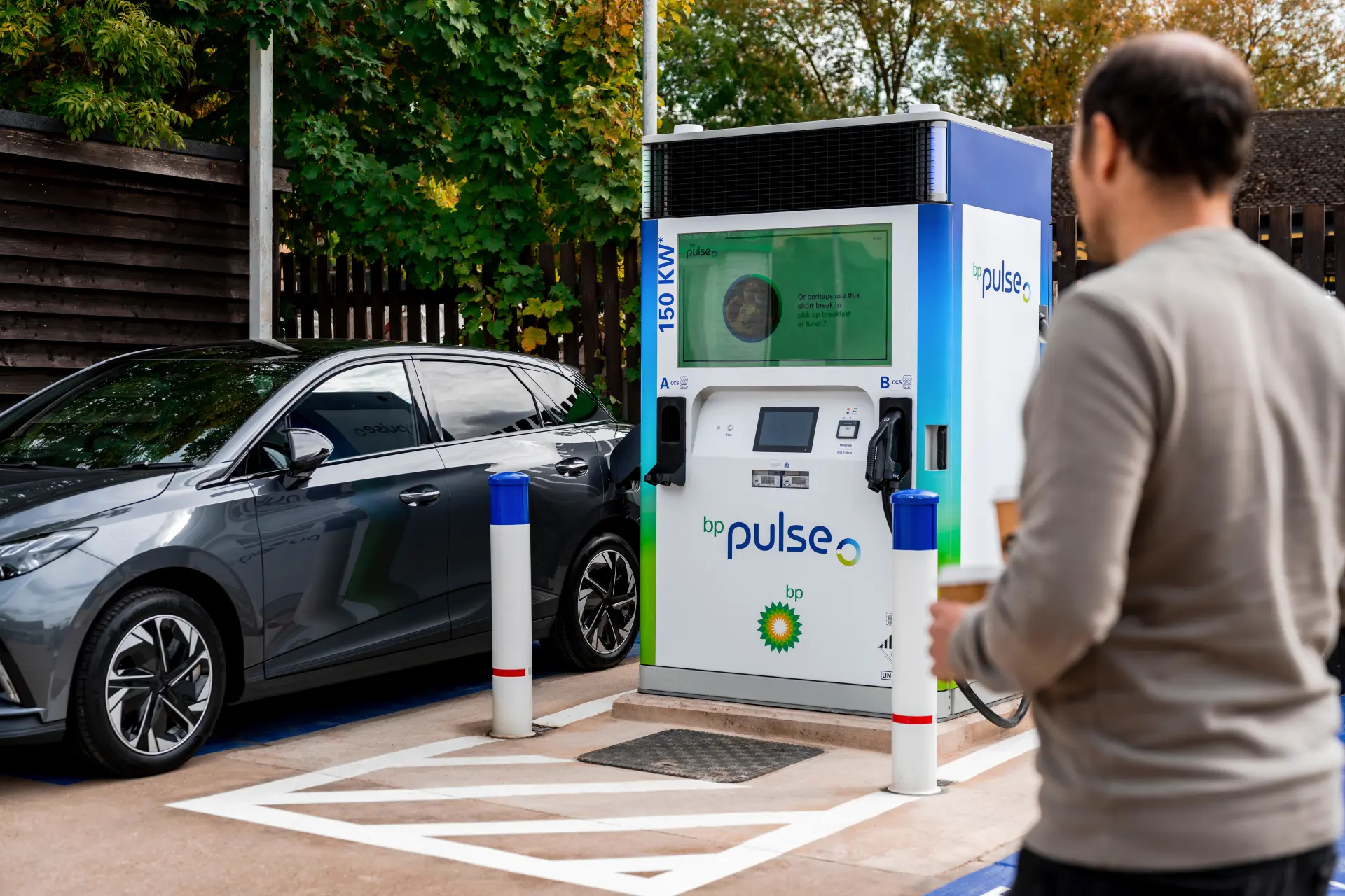 An EV driver using a bp pulse 150 charging point to charge an electric car