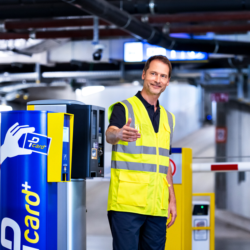 Arbeiten in den Parkeinrichtungen. Mitarbeiter steht in der Parkeinrichtung und hilft.