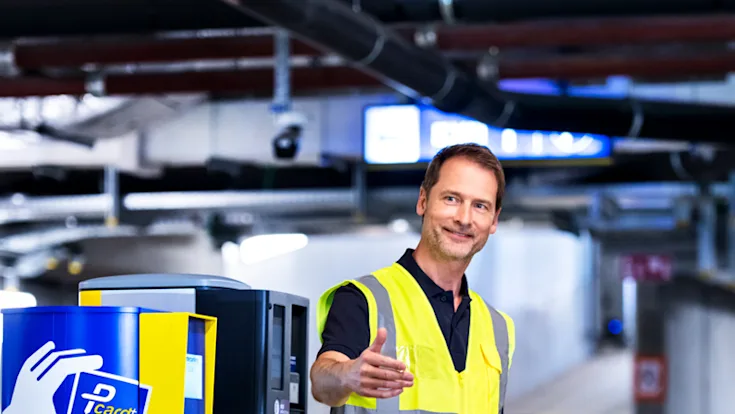 Arbeiten in den Parkeinrichtungen. Mitarbeiter steht in der Parkeinrichtung und hilft.