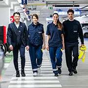 vier Contipark-Mitarbeiter laufen nebeneinander durch eine Tiefgarage