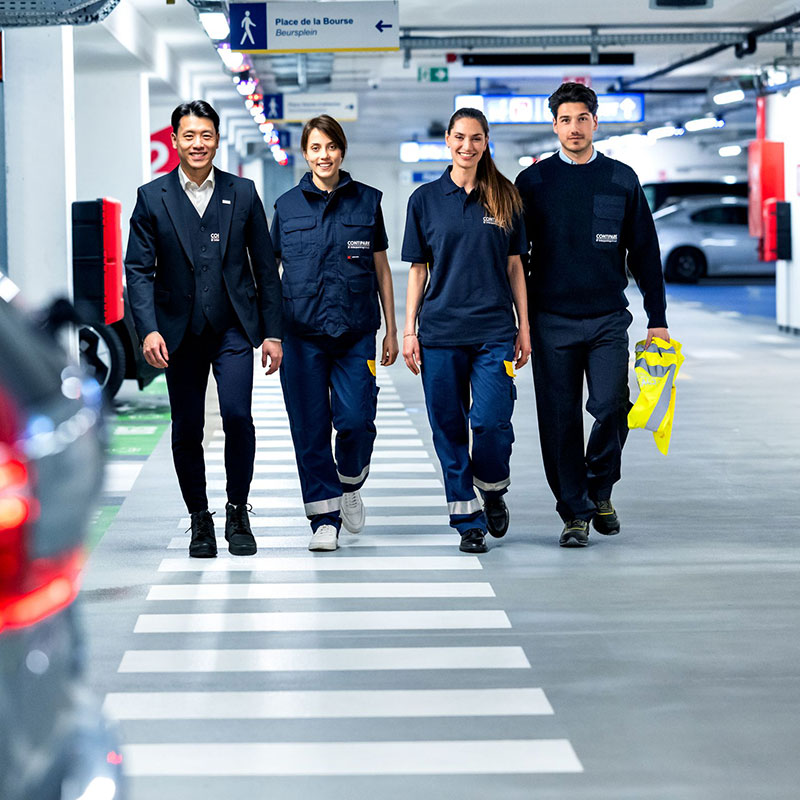 Contipark Mitarbeiter gehen zusammen durch ein Parkhaus