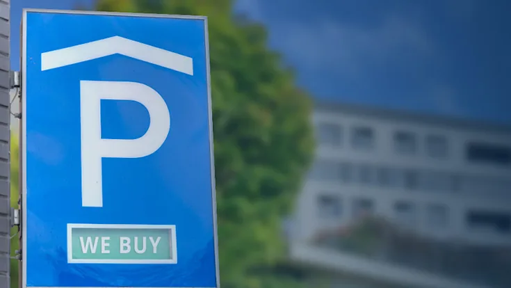 Parkhausschild vor einem mehrstöckigen Haus im Hintergrund