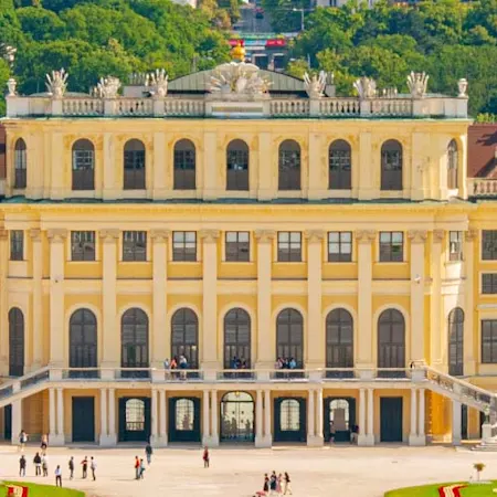 Parken in Wien: Das Schloss Schönbrunn erstreckt sich im Vordergrund des Bildes hinter ihr ist die Stadt Wien zu sehen.