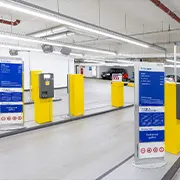 Einfahrt in eine Tiefgarage mit Informationsstelen und Schrankenterminals