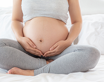 Schwangere Frau hält ihren Bauch