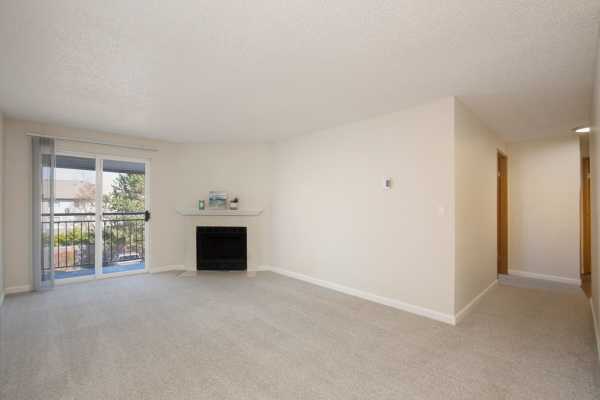 Photo of living room area with fireplace and deck at Casa Blanca apartments.