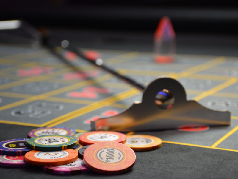 Croupiers rake and chips on a roulette table