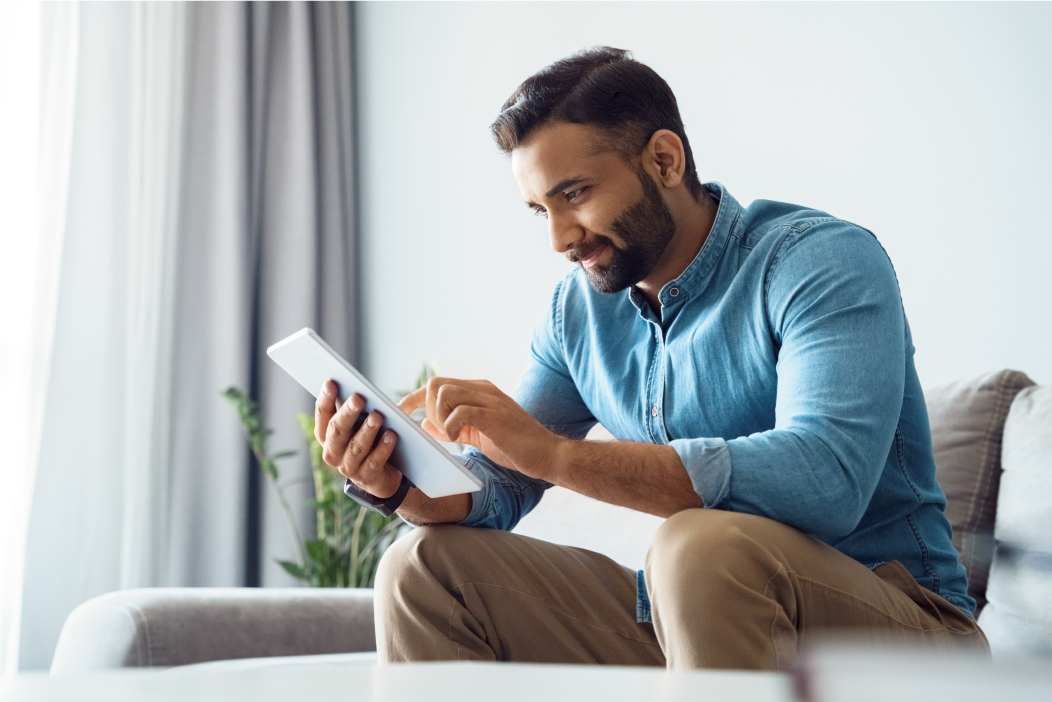 Man on couch using tablet