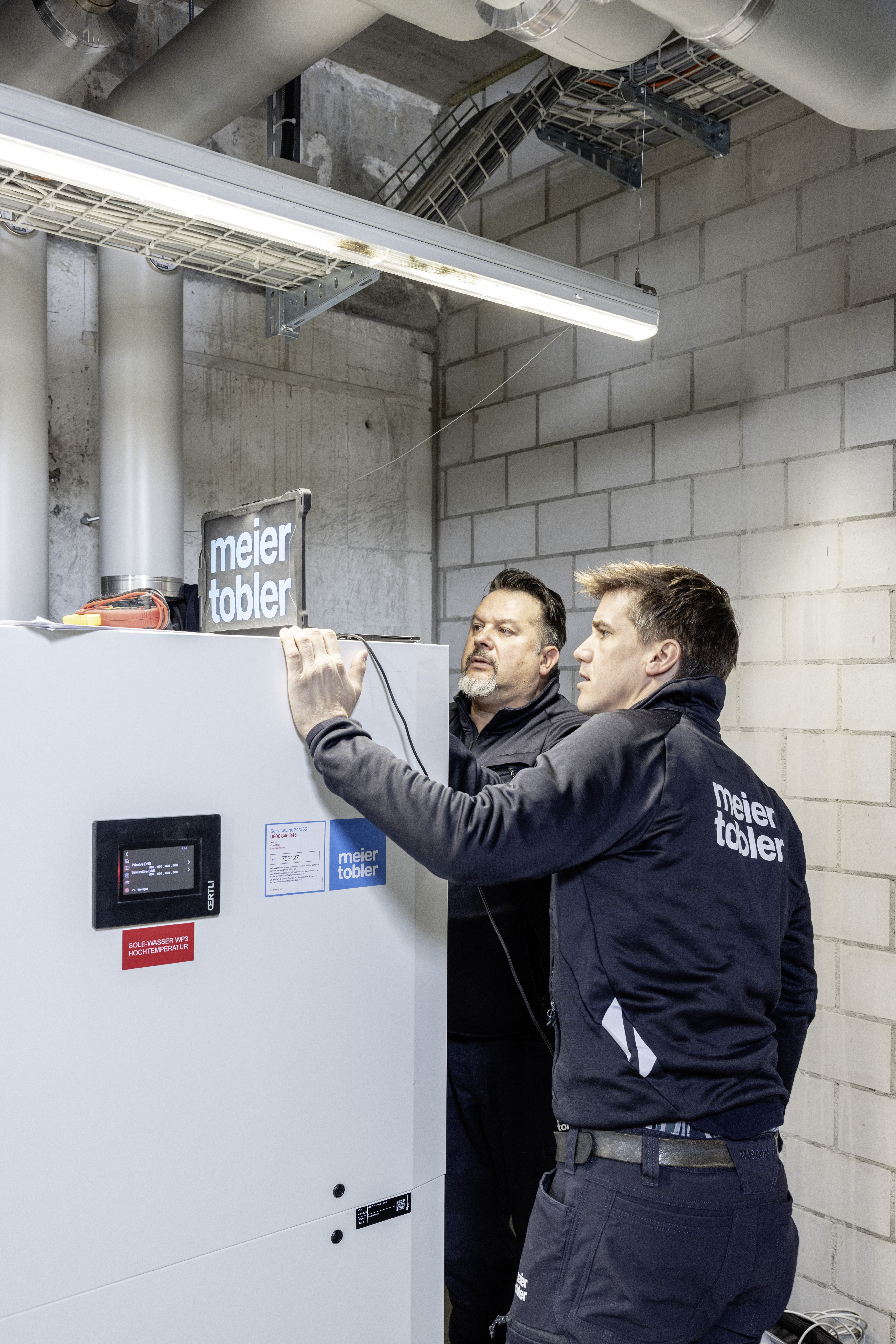 Techniciens de service effectuent la maintenance d’une pompe à chaleur et contrôlent les composants