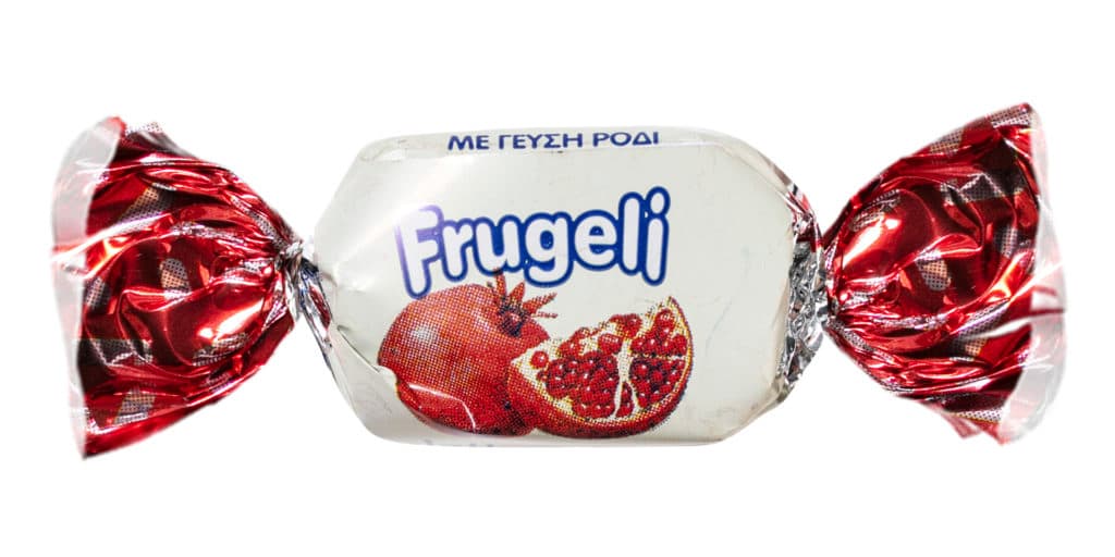 A small wrapped candy labeled "Frugeli" with an illustration of a pomegranate