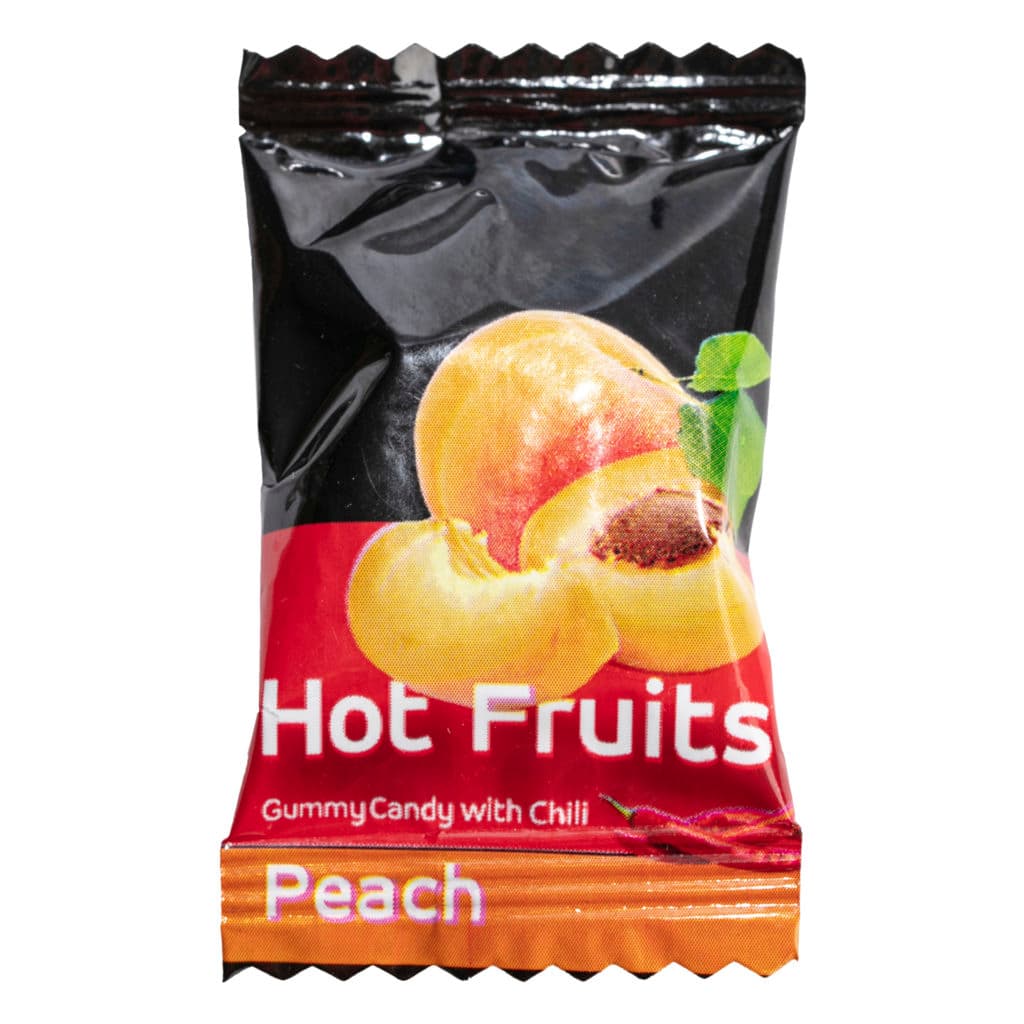 An individually wrapped gummy labelled "Hot fruits: peach". There is an illustration of a peach on it.